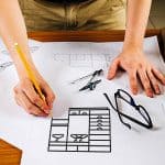 A designer sketching a cabinet design, showcasing customized cabinetry options.