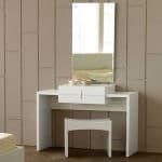 A white dressing unit with an attached mirror.