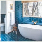 Modern bathroom with a white freestanding tub and blue color handmade tiles.